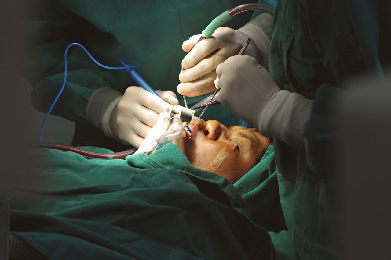 Surgeons in sterile environment performing delicate facial surgery with precision instruments.