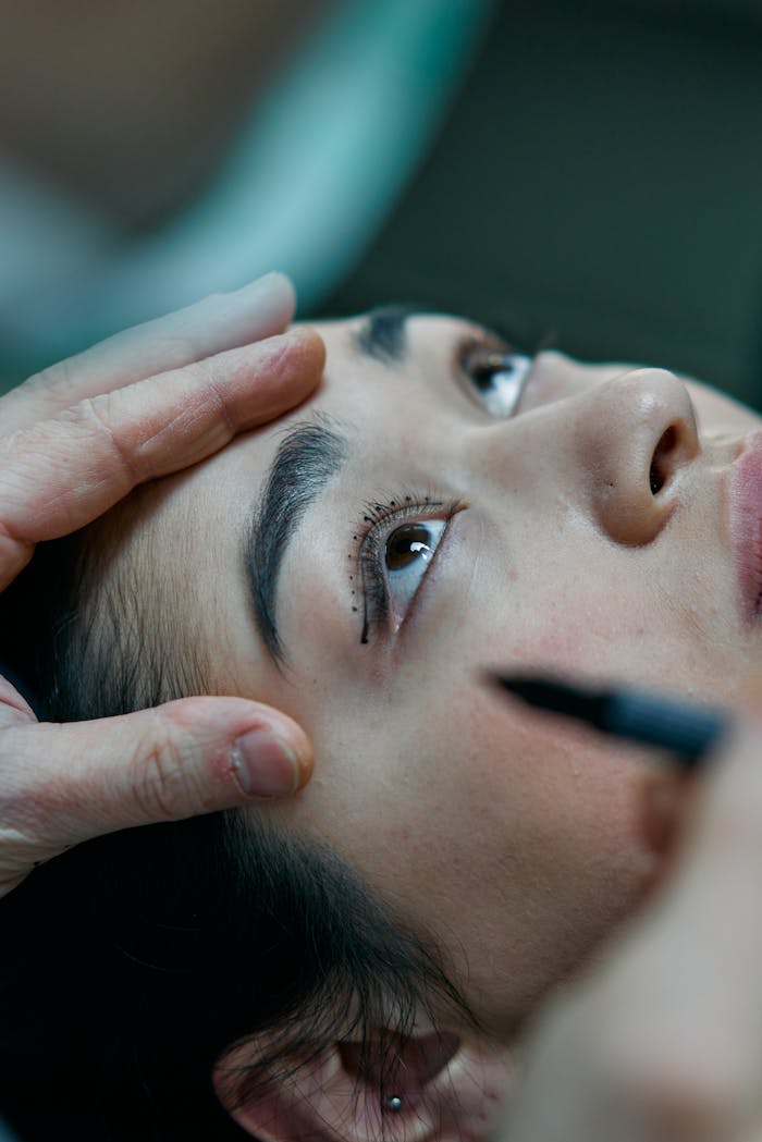 Person preparing for cosmetic eye surgery with markings.